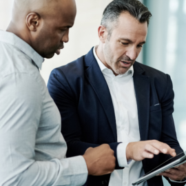 man showing another man his ipad