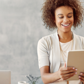 woman looking at her ipad and smiling