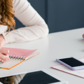 woman writing on a notepad