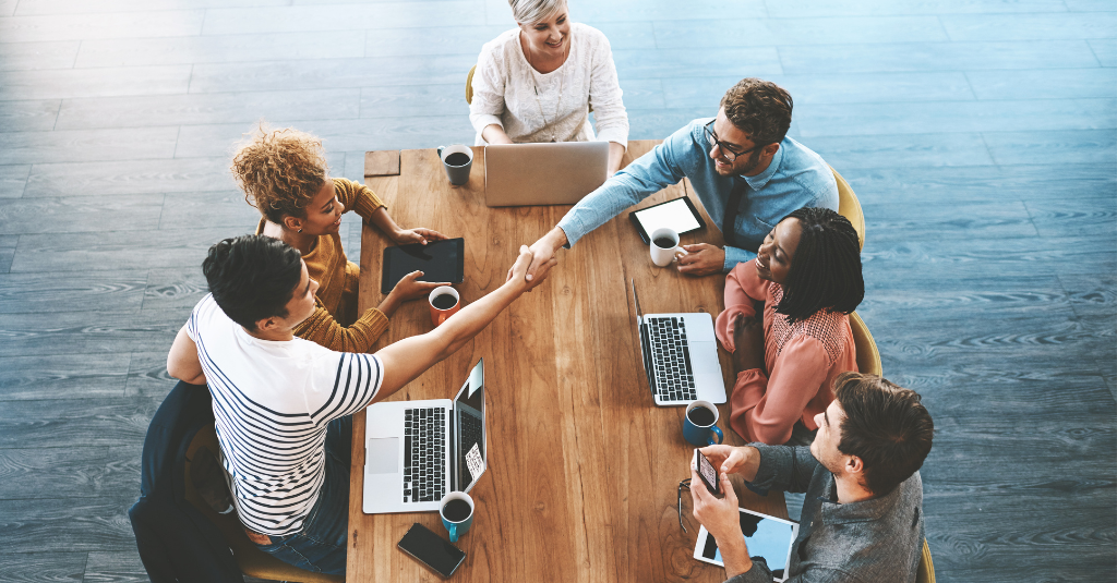 people shaking hands at a table