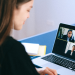 A person in a virtual meeting with a meeting notes.